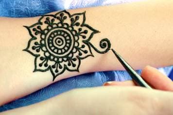 black mehendi tattoo on the arm
