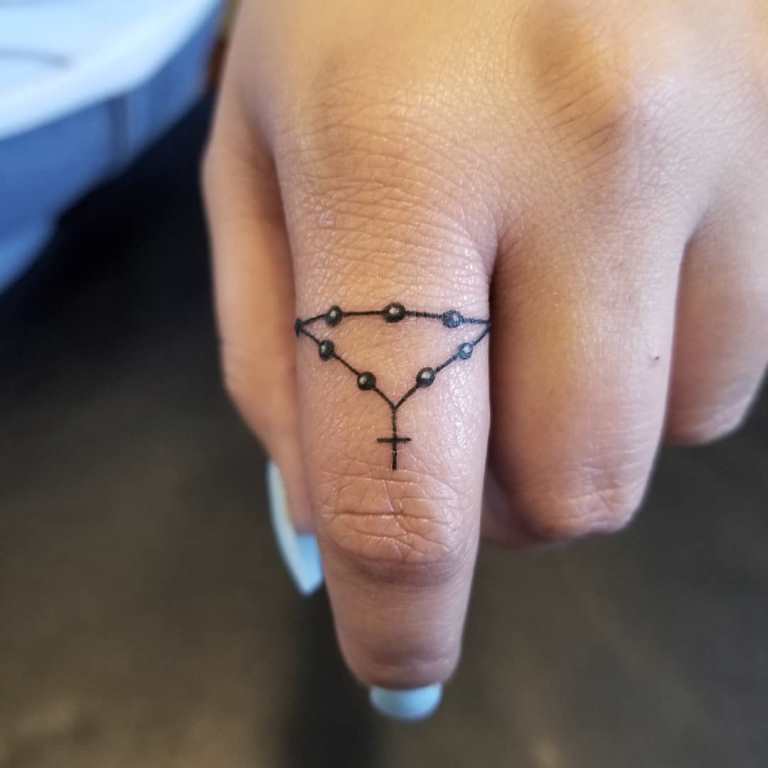 Kreuz auf dem Finger Tattoo bedeutet