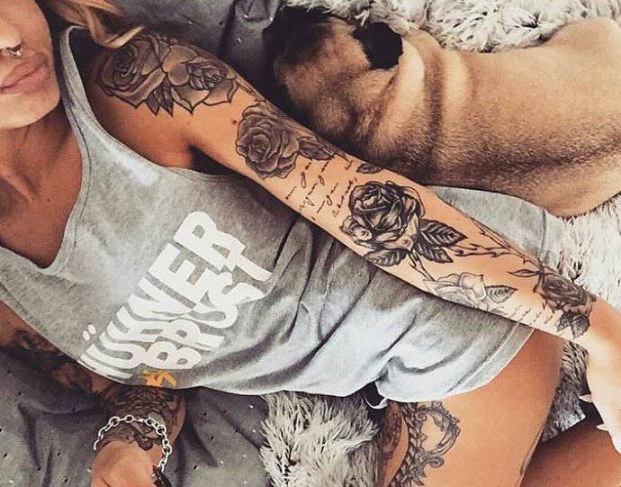 ragazza con tatuaggio vicino al cane