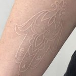 Weißer Umriss Tattoo auf Arm