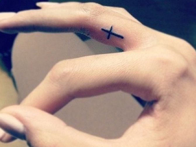 Cross tattoo on the finger - the hallmark of thieves