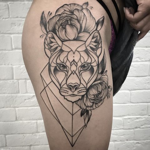 Tatuaje de pantera con flores en el muslo