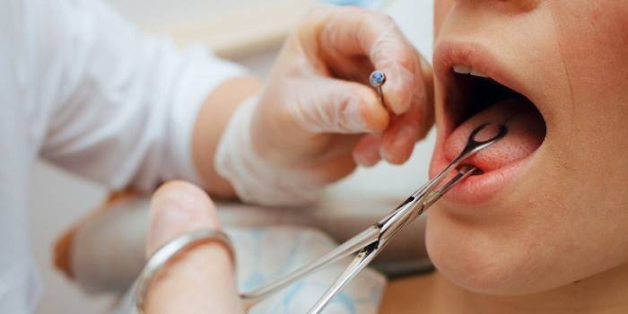 Un infirmier se prépare pour un piercing de la langue