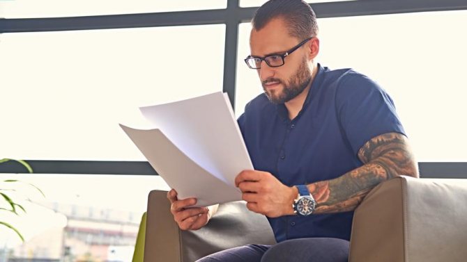 homme avec des tatouages dans le bureau