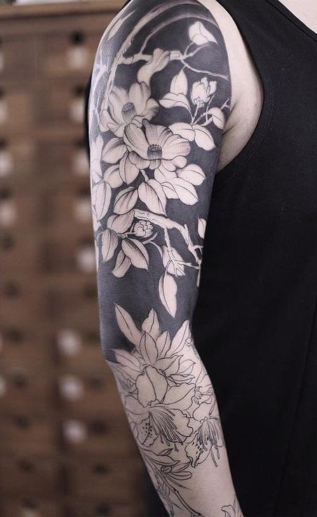 Man's tattoo on hand with Blackwork and flowers