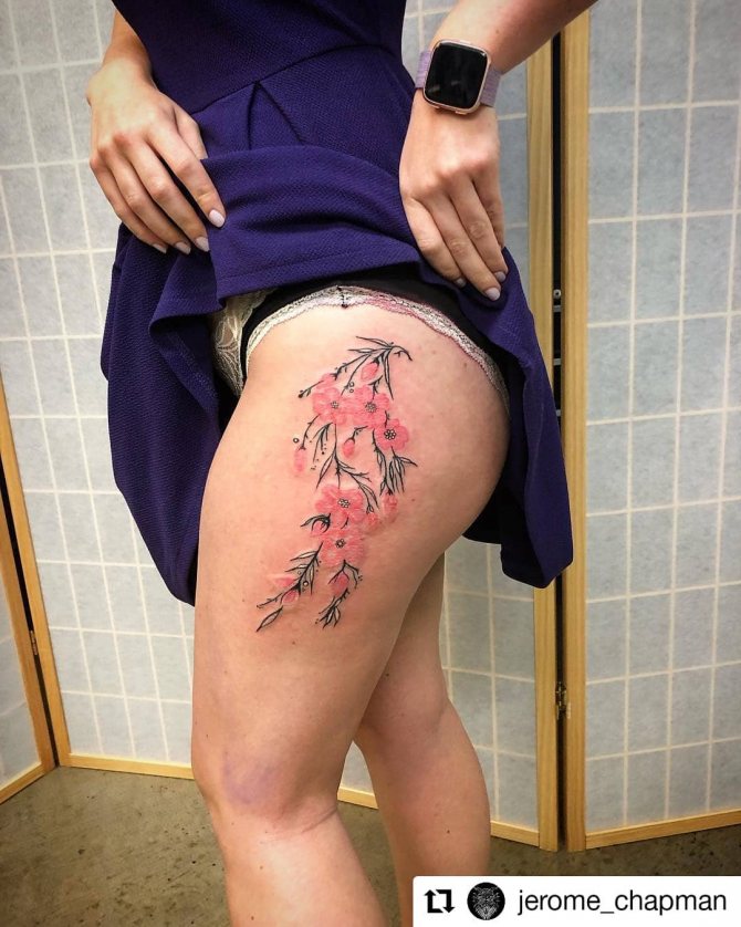 Tatouage sexy de branches de cerisier sur la cuisse d'une femme