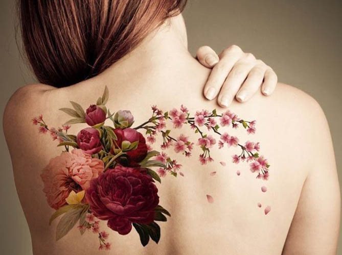 Tetovált virágok. Fekete-fehér vázlatok, virágok a karon, a kulcscsonton, a lábon, a combon.