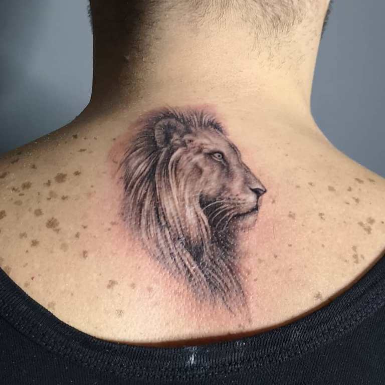 Tatouage d'une tête de lion sur le cou