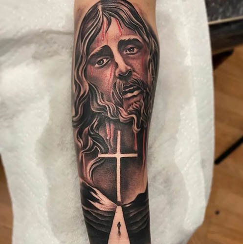 Tatovering af Jesus på arm, ryg, skulder, bryst. Betydning, på korset, med djævelen, maskine, due, due