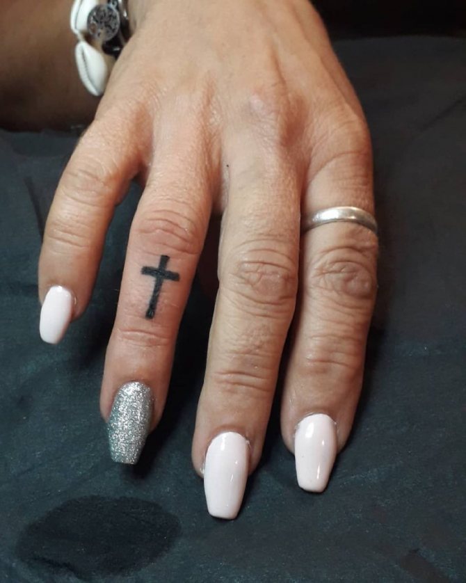 Tattoo Kreuz auf Daumen