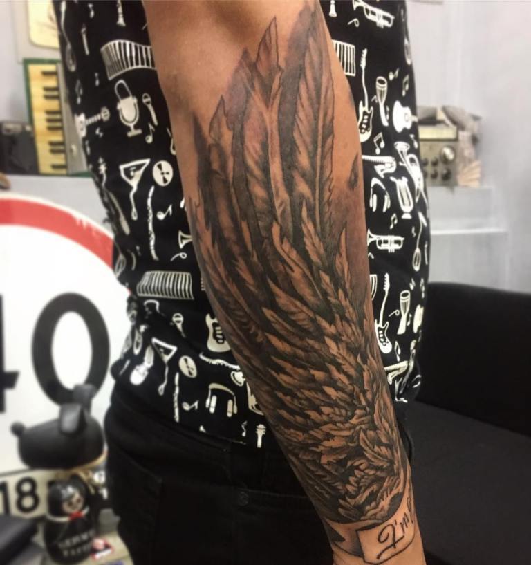 Le tatouage d'ailes est superbe sur l'avant-bras d'un homme.