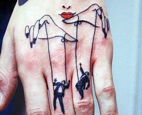Tatouage marionnettiste et marionnettes sur le poignet