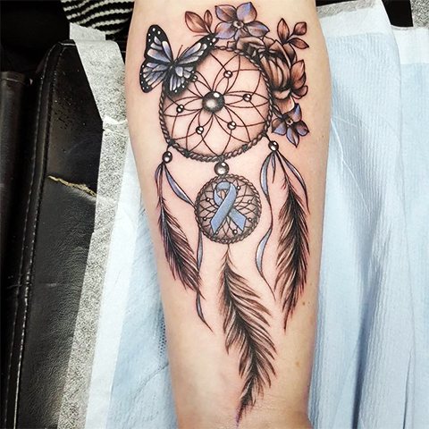 Tatouage d'un attrape-rêves et d'un papillon