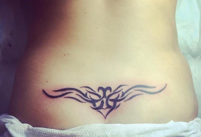 Tatouage sur le coccyx pour les filles. Photo et signification