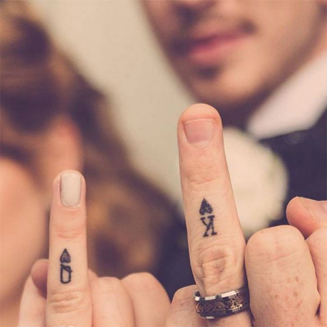 Tattoo on fingers as a King and Queen of Cards