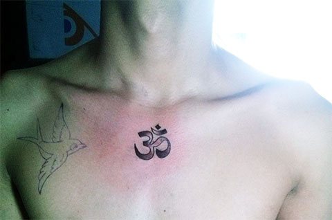 Tatuaje de Om en el pecho de un hombre