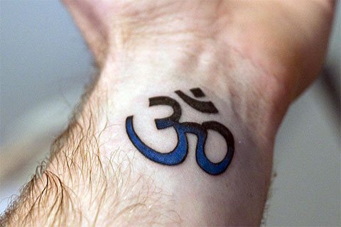 Tatuaje Om en la muñeca