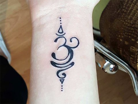 Tatuaje Om en la muñeca