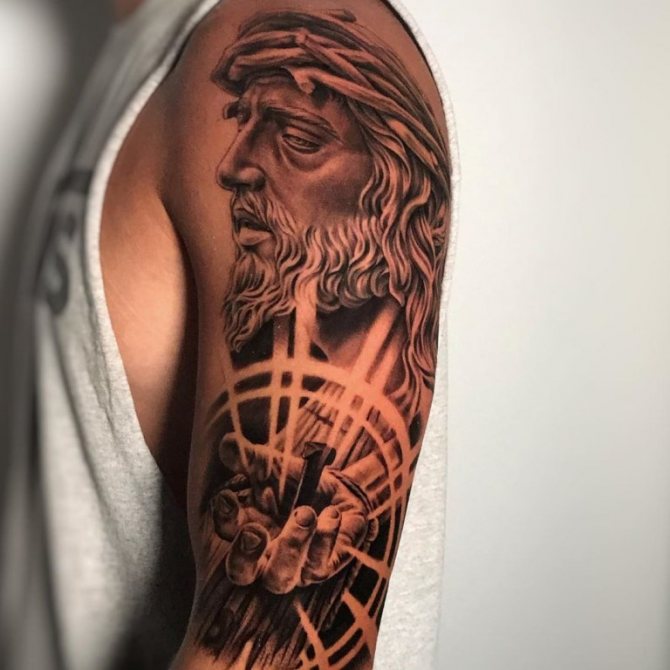 tatuaje de cristo crucificado en el brazo