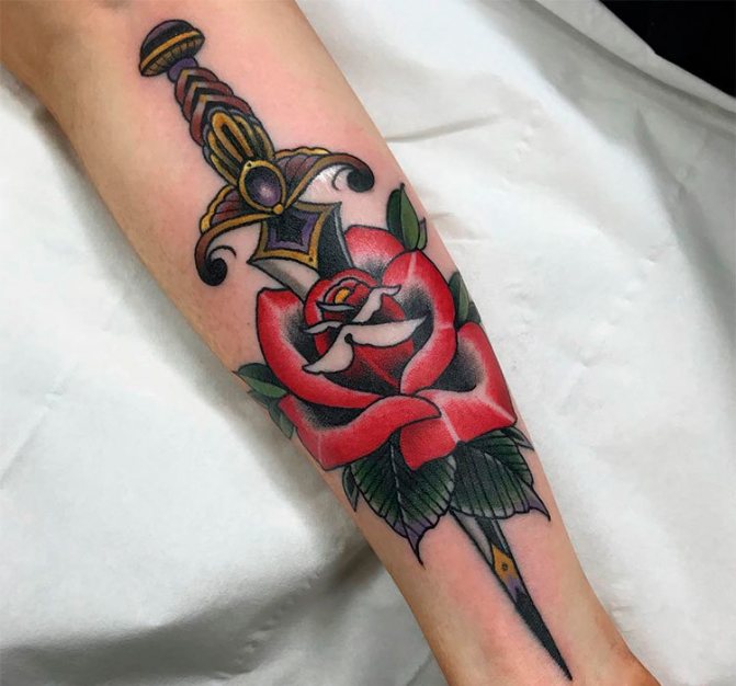 Rose tatouée avec une dague sur le bras