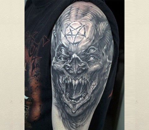 Tattoo of a demon on his shoulder