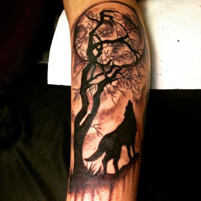Tatouage d'un loup hurlant sur la lune sur son épaule