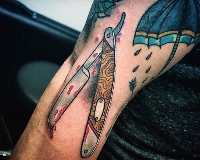 tattoo umbrella and razor on the arm