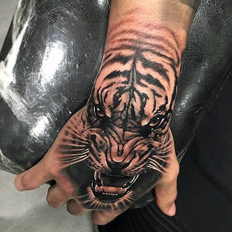 Tatouage d'un tigre souriant sur sa main