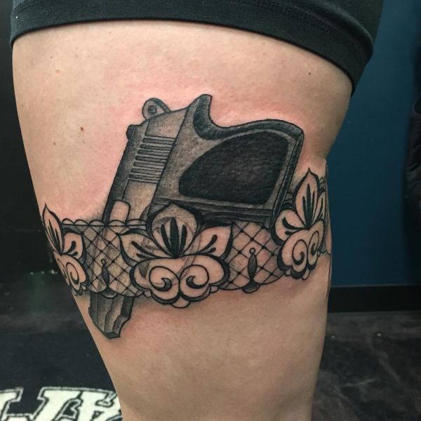 Tatouage d'une jarretière avec un pistolet