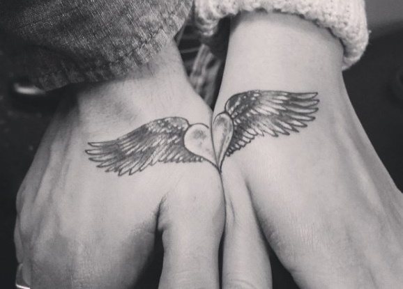 女子の二の腕にタトゥー、隙間に男性、碑文。写真