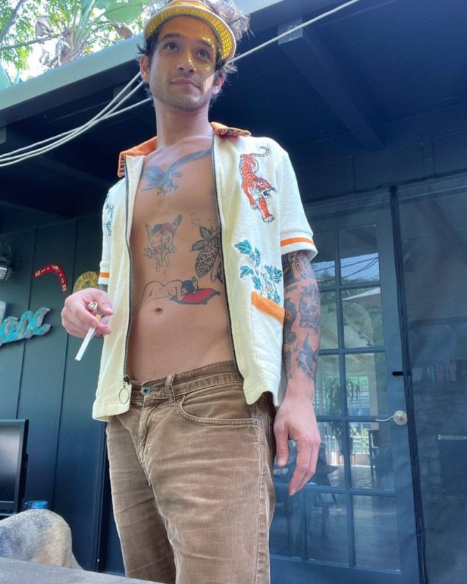 Tyler Posey se tatúa el pecho y el torso. Actor con camisa abierta.