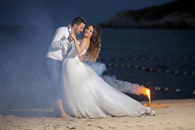 Bride and groom dancing on the beach at night